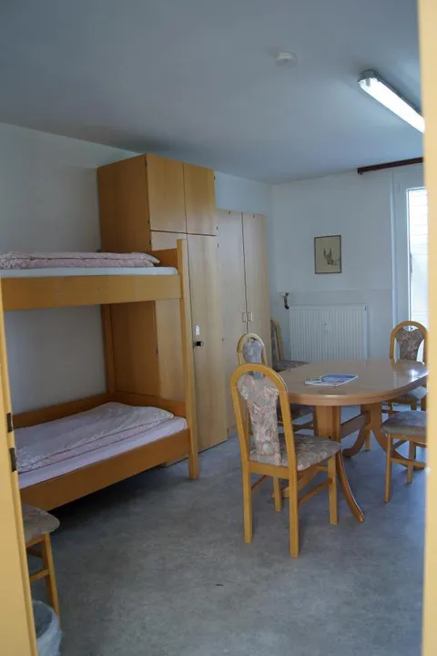 Mehrbettzimmer mit großem Tisch und Schrank